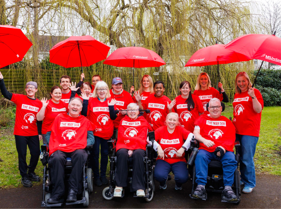 Group of people in red t-shirt holding red umbrellas 